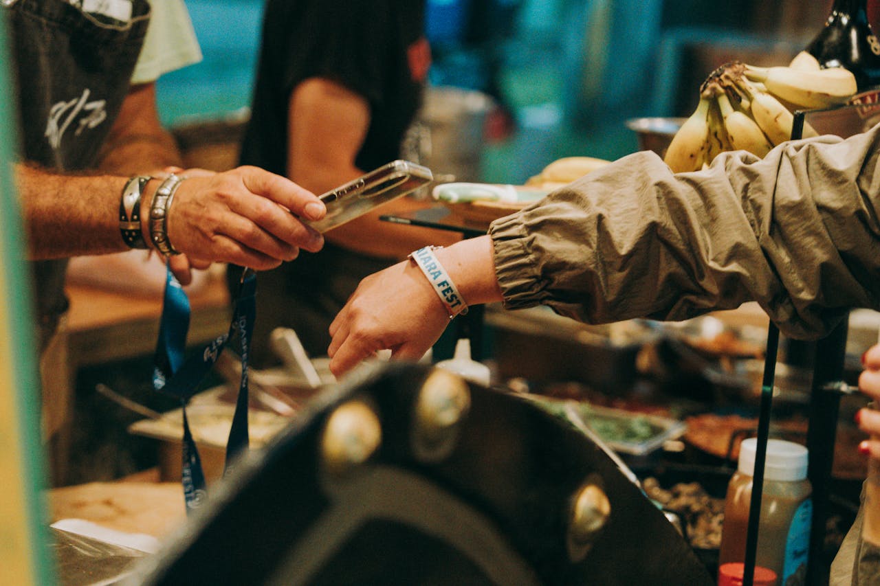 A lively festival food purchase transaction between vendor and customer.
